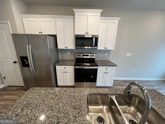 a kitchen that has a sink a refrigerator and a sink