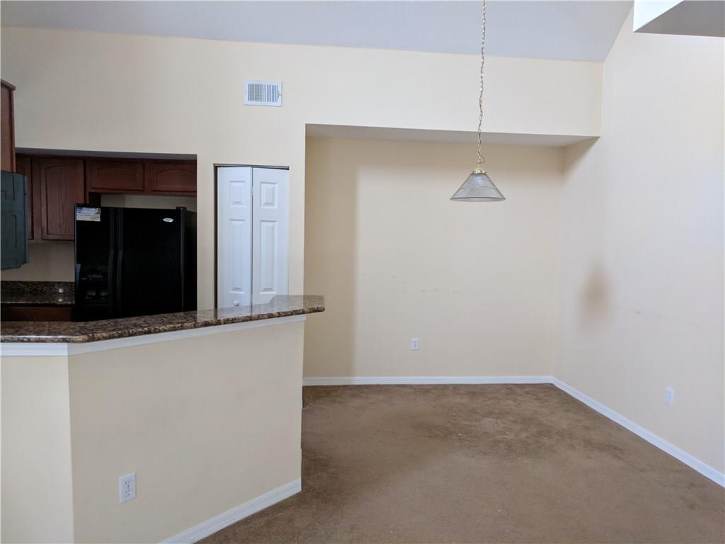 1645 Southeast Pomeroy Street, Unit 42 Stuart, FL 34997 - Photo 15 of 29 a view of a refrigerator in kitchen and an empty room