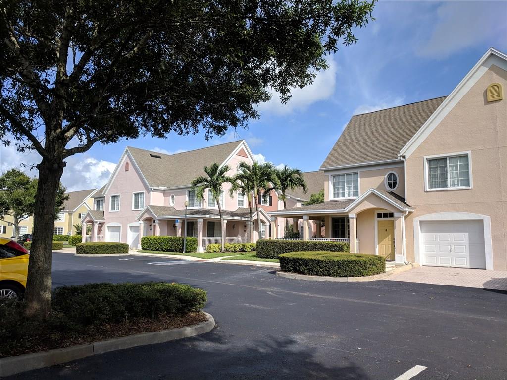 1645 Southeast Pomeroy Street, Unit 42 Stuart, FL 34997 - Photo 29 of 29 a front view of a house with a garden and trees