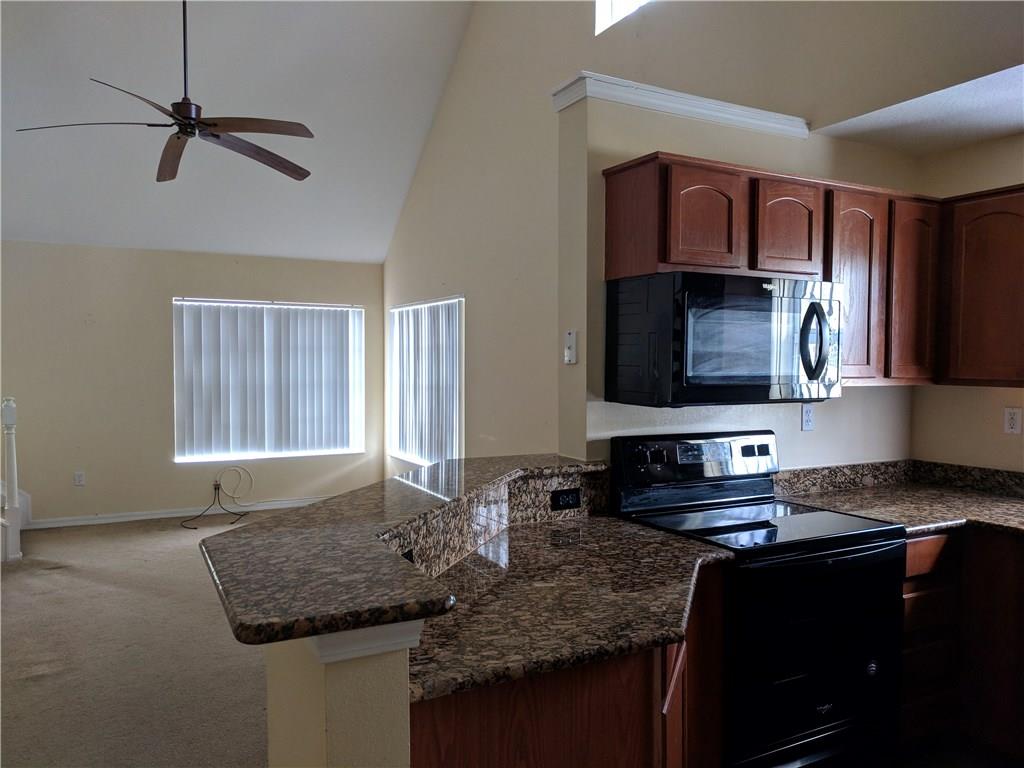 1645 Southeast Pomeroy Street, Unit 42 Stuart, FL 34997 - Photo 8 of 29 a kitchen with granite countertop a sink a counter top space cabinets and stainless steel appliances