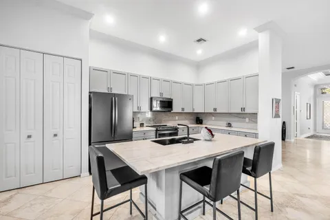 a large kitchen with a large counter top appliances and cabinets