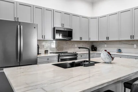 a kitchen with white cabinets and stainless steel appliances