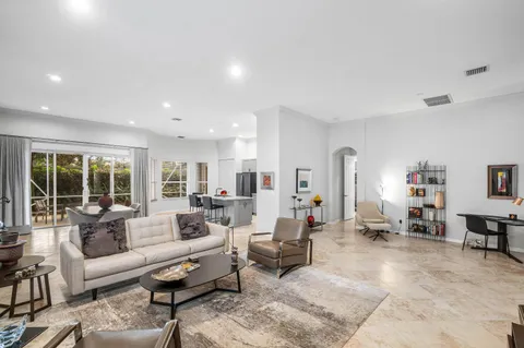 a living room with furniture a flat screen tv and a window