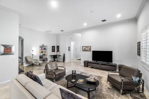 a living room with furniture and floor to ceiling window