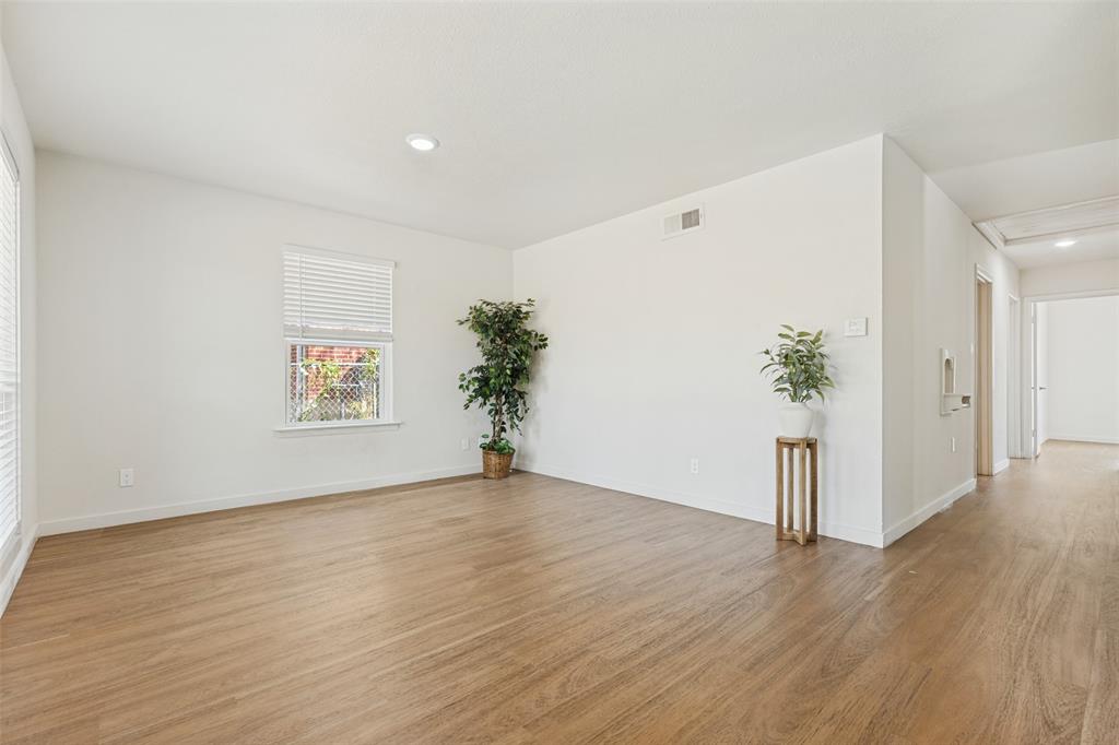 1215 Fordham Road Dallas, TX 75216 - Photo 4 of 25 Wood-finish flooring throughout, white walls, recessed lighting, and multiple windows with blinds