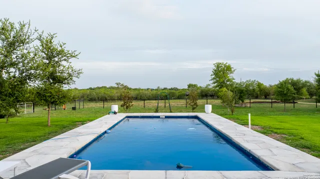 a view of a lake with a yard and large trees