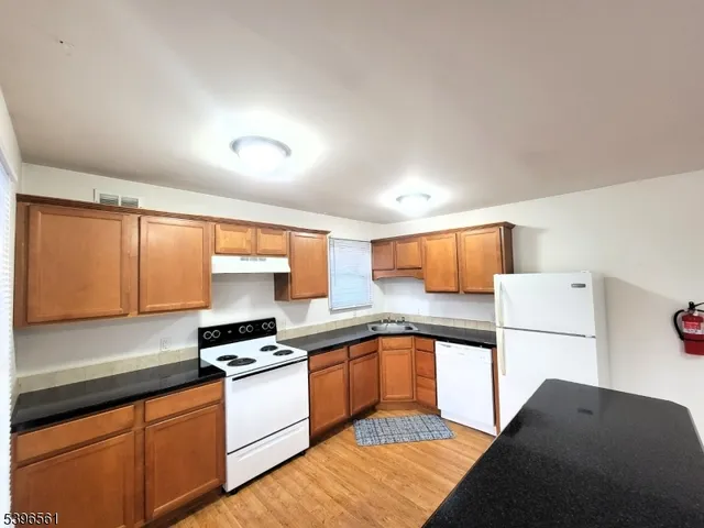 a kitchen with stainless steel appliances granite countertop a sink counter space and cabinets