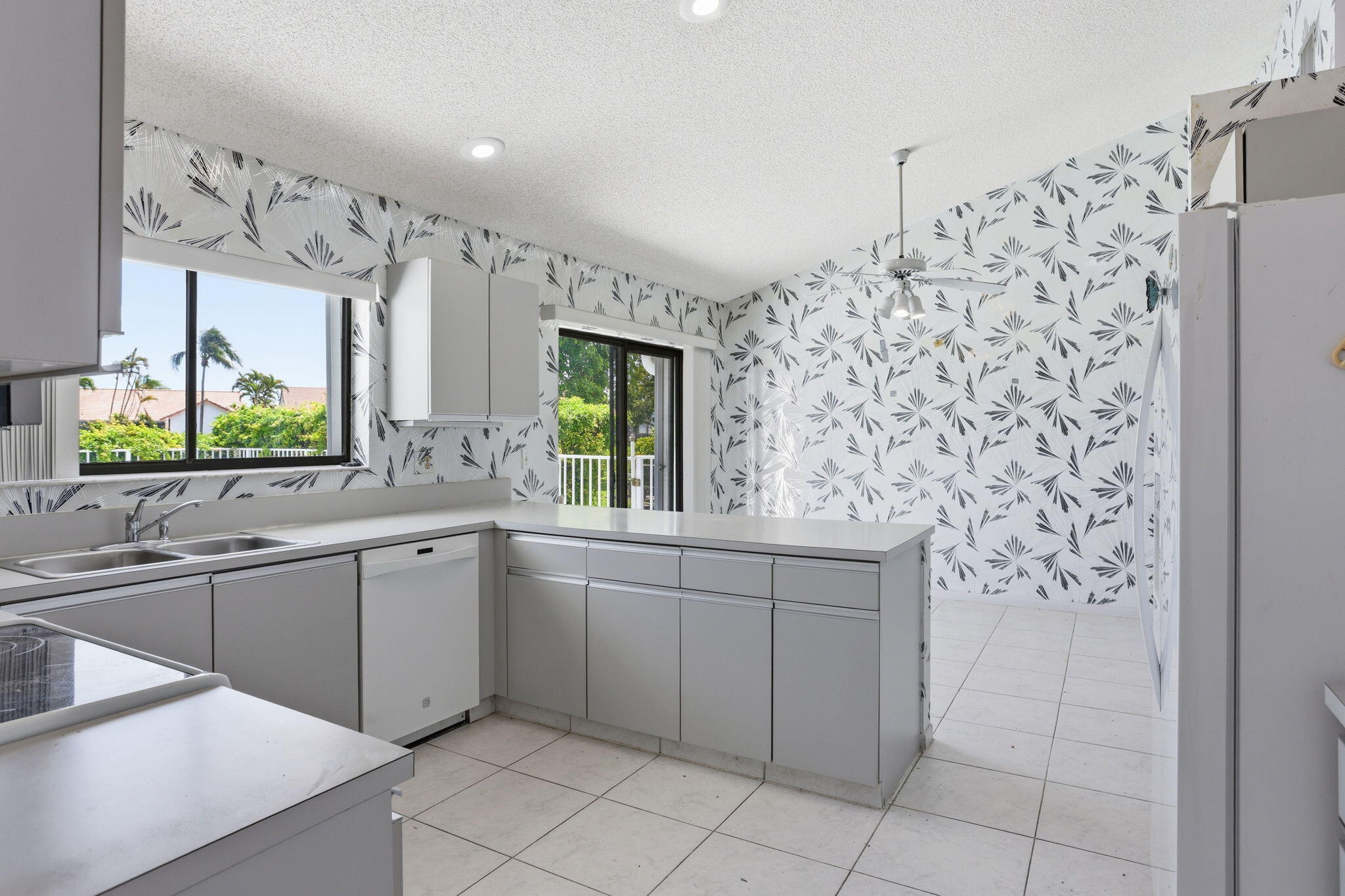 9476 El Clair Ranch Road Boynton Beach, FL 33437 - Photo 12 of 29 a kitchen with stainless steel appliances a sink and a refrigerator