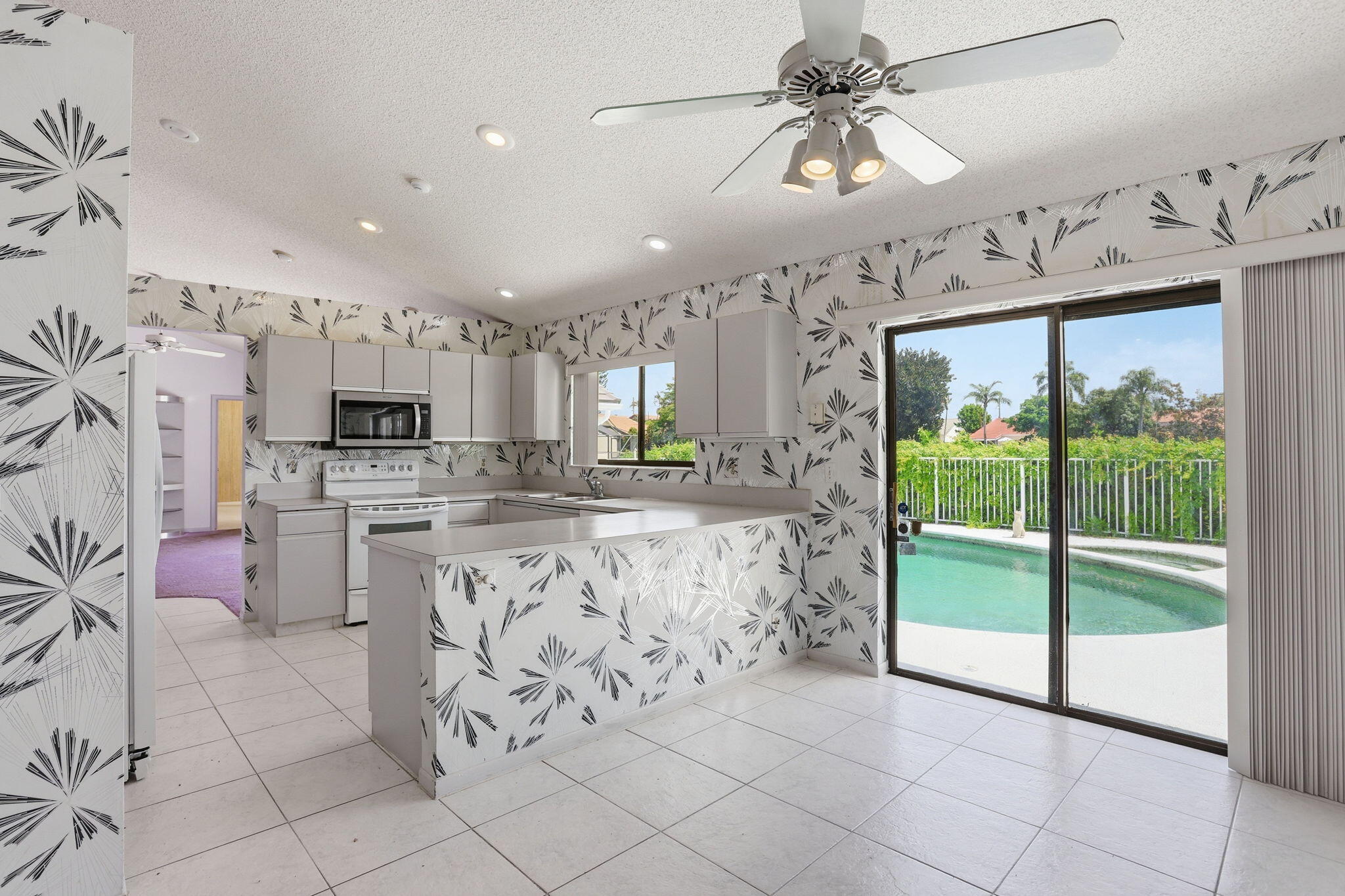 9476 El Clair Ranch Road Boynton Beach, FL 33437 - Photo 15 of 29 a kitchen with stainless steel appliances kitchen island granite countertop a refrigerator a stove top oven a sink with island and chairs