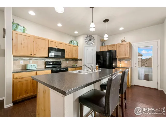 a kitchen with kitchen island a sink counter and chairs