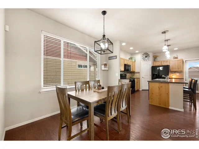 a view of a dining room and livingroom with furniture wooden floor a chandelier
