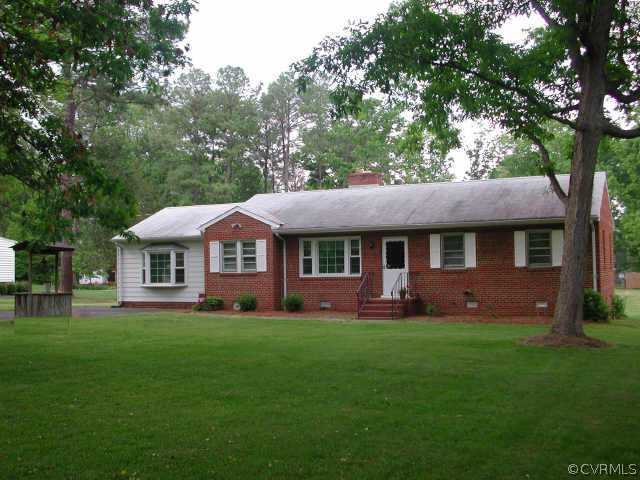 a front view of a house with a yard and trees