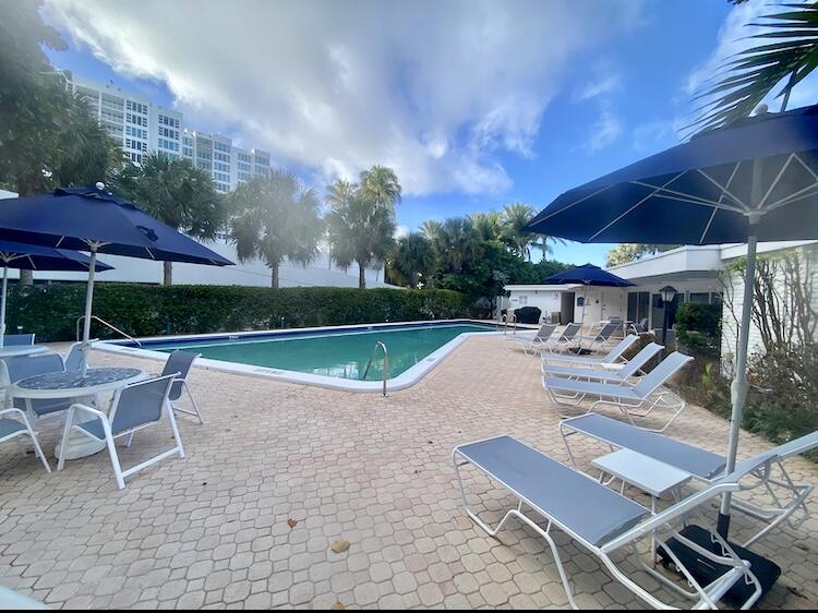 1530 South Ocean Boulevard, Unit 303 Lauderdale-by-the-Sea, FL 33062 - Photo 15 of 27 a view of a patio with a table and chairs under an umbrella