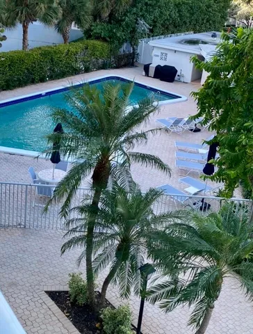 a view of a swimming pool with a yard and plants