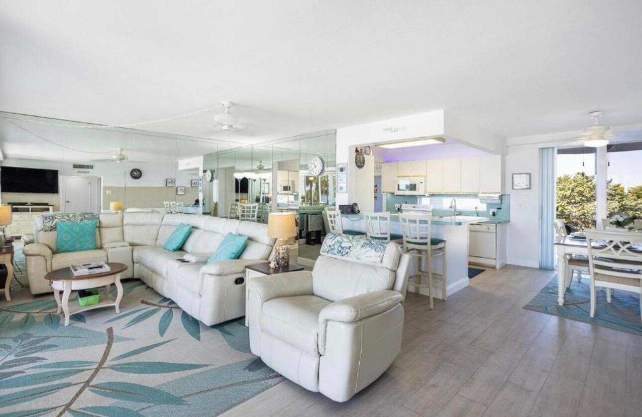 1530 South Ocean Boulevard, Unit 303 Lauderdale-by-the-Sea, FL 33062 - Photo 5 of 27 a living room with furniture and a large window with kitchen view