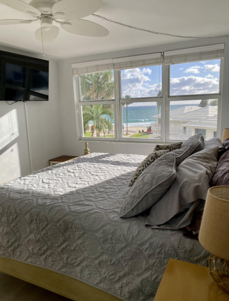 1530 South Ocean Boulevard, Unit 303 Lauderdale-by-the-Sea, FL 33062 - Photo 7 of 27 a bed sitting in a bedroom next to a window