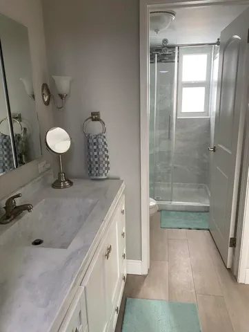 a bathroom with a granite countertop sink a toilet and shower