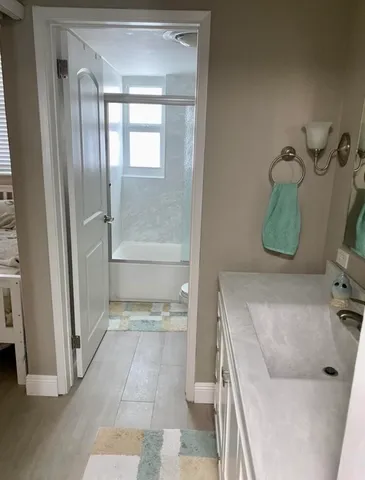 a bathroom with a tub sink and mirror