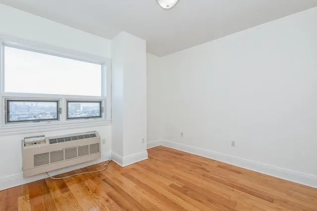 a view of a livingroom with wooden floor and a window