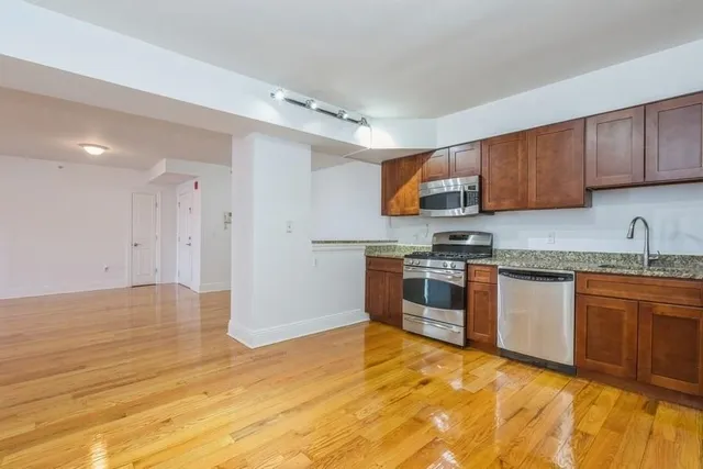 a kitchen with granite countertop a stove cabinets and a sink