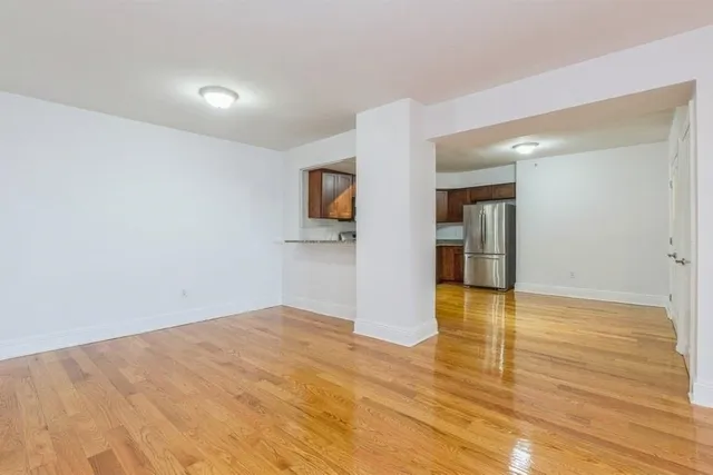 a view of empty room with wooden floor