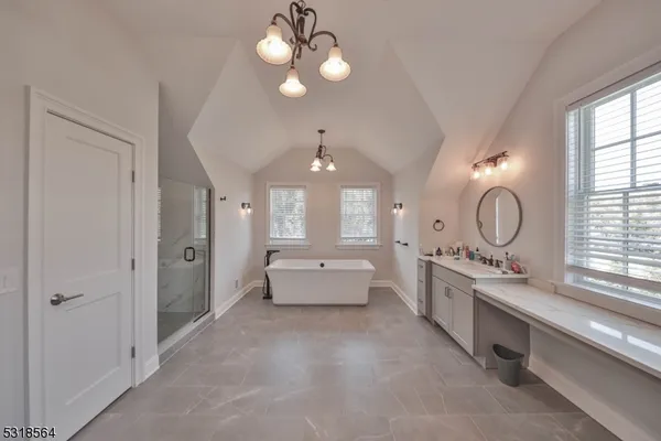 a large spacious bathroom with a double vanity sink a large mirror and a bathtub