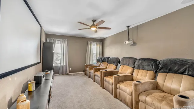 a living room with furniture ceiling fan and a rug