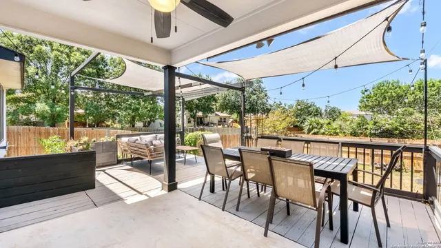 a view of a patio with a table chairs and a floor to ceiling window