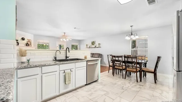a kitchen with a dining table chairs and white appliances