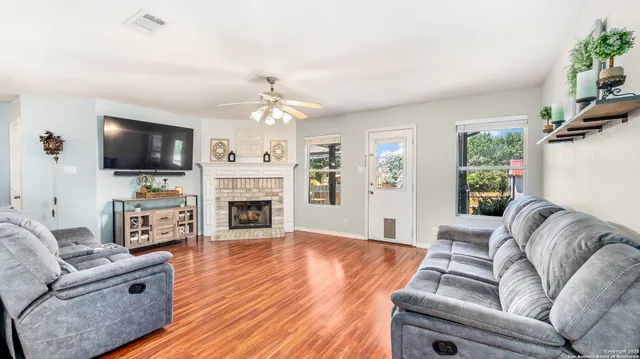 a living room with furniture a fireplace and a flat screen tv