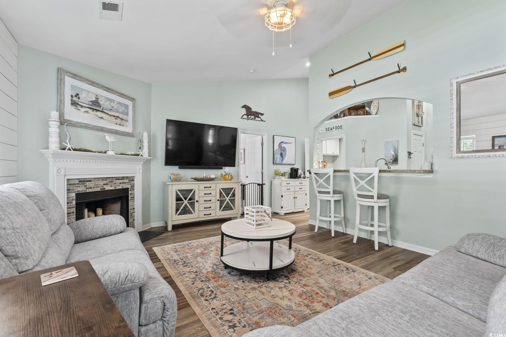 1604 Langley Drive Longs, SC 29568 - Photo 15 of 37 Living room featuring dark wood-style floors, a fireplace, ceiling fan, and high vaulted ceiling