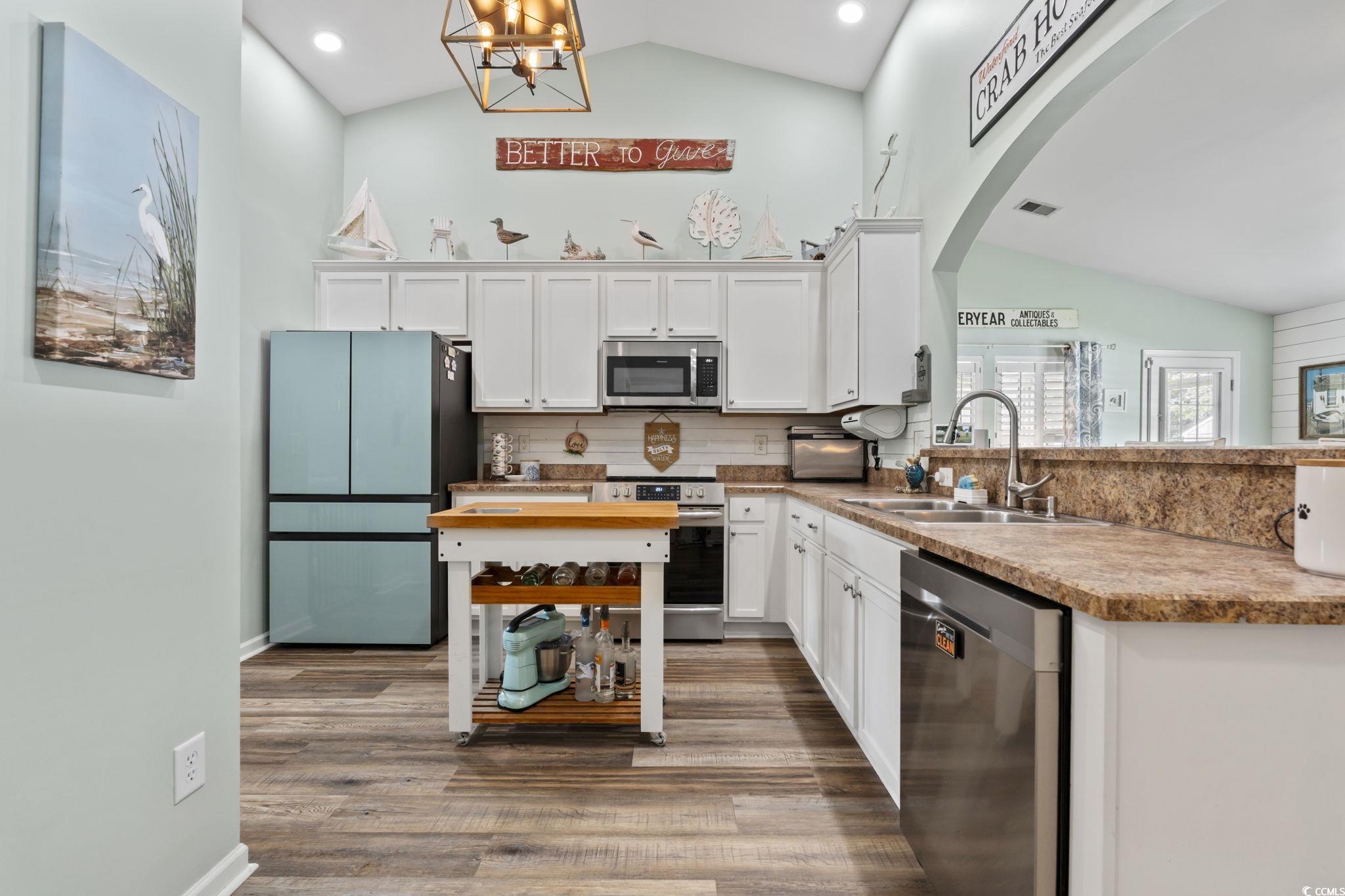 1604 Langley Drive Longs, SC 29568 - Photo 21 of 37 Kitchen with appliances with stainless steel finishes, white cabinetry, light wood-type flooring, decorative backsplash, and a chandelier
