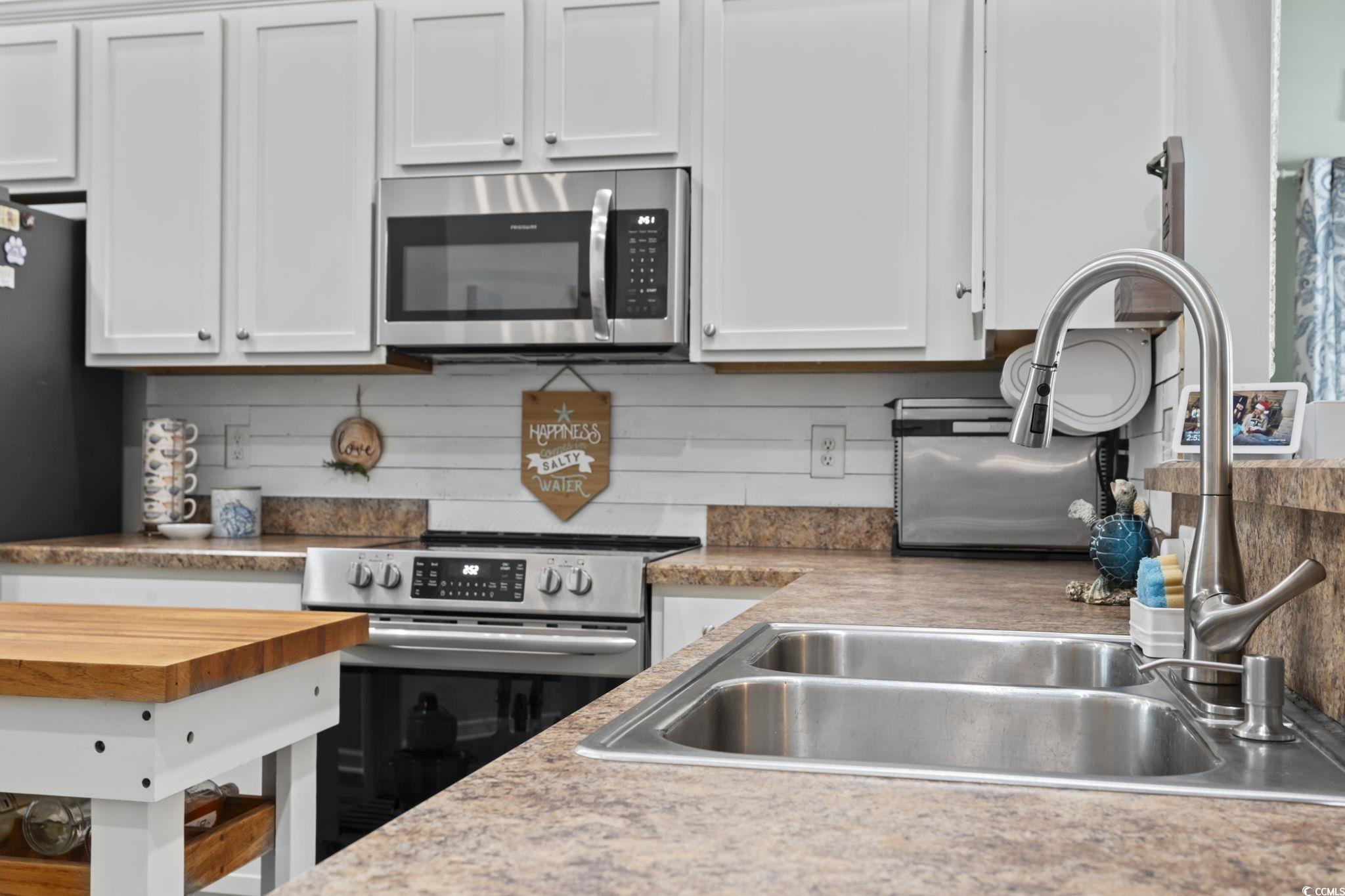 1604 Langley Drive Longs, SC 29568 - Photo 23 of 37 Kitchen featuring appliances with stainless steel finishes, white cabinetry, wood counters, and tasteful backsplash