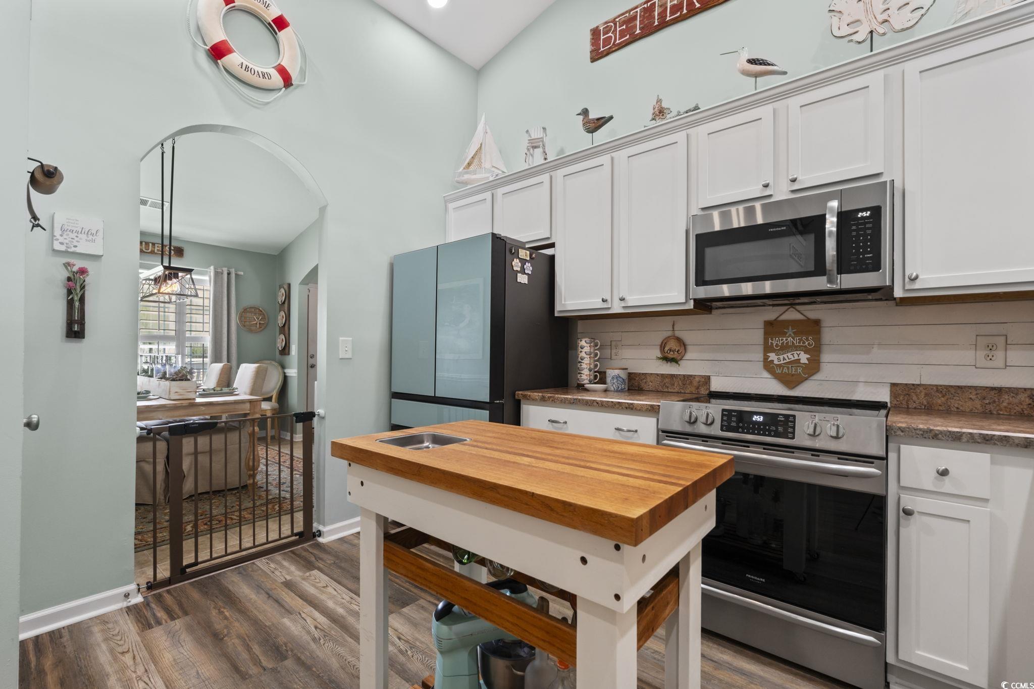 1604 Langley Drive Longs, SC 29568 - Photo 25 of 37 Kitchen with stainless steel appliances, dark wood-style flooring, white cabinetry, backsplash, and a towering ceiling
