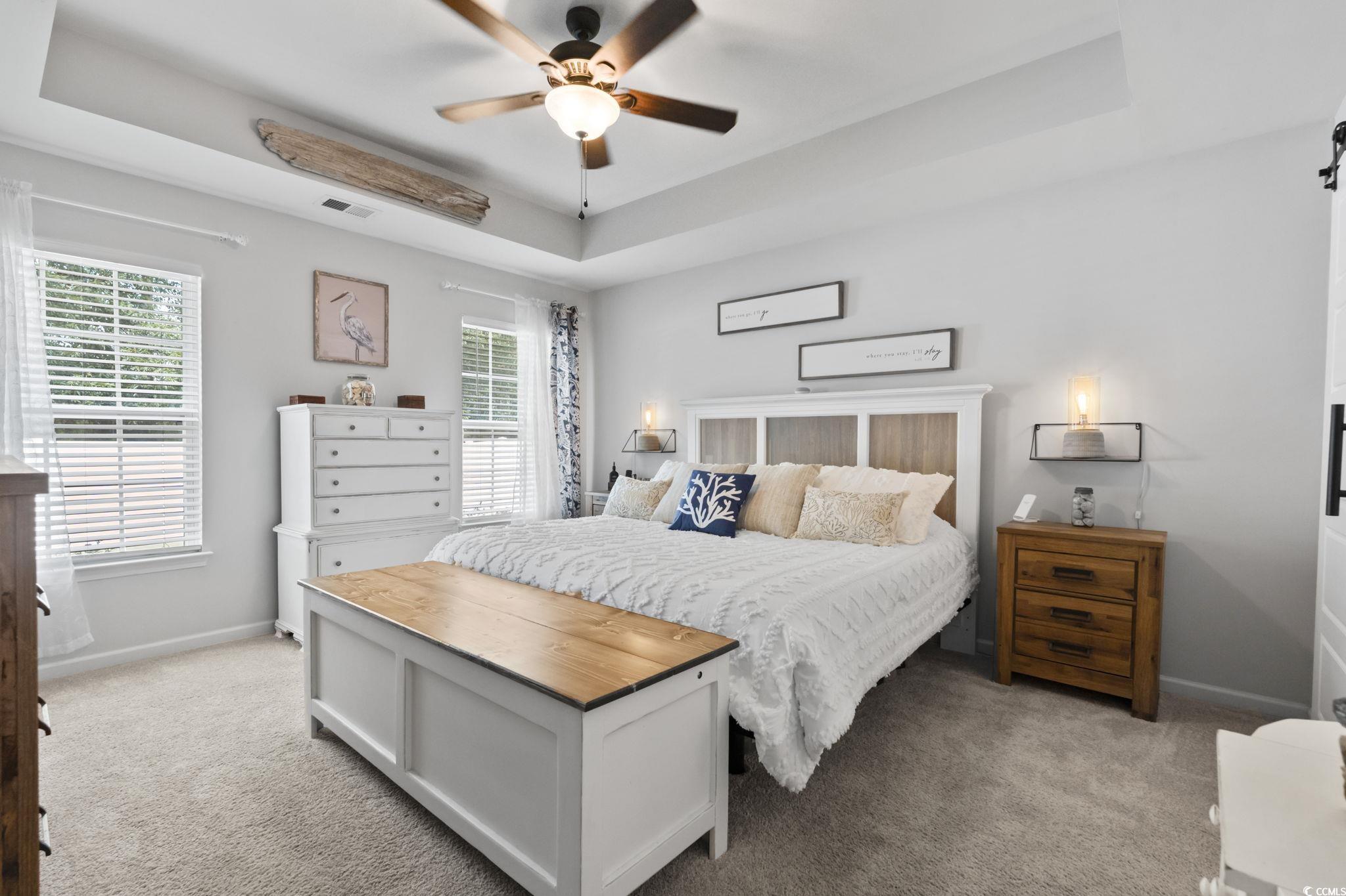 1604 Langley Drive Longs, SC 29568 - Photo 26 of 37 Bedroom featuring a tray ceiling, light colored carpet, and a ceiling fan