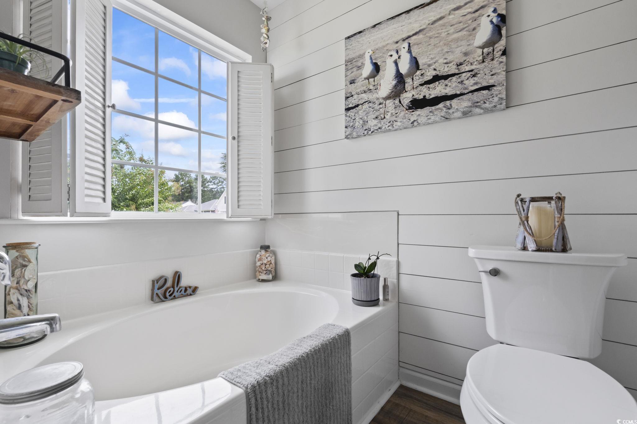 1604 Langley Drive Longs, SC 29568 - Photo 30 of 37 Bathroom featuring a garden tub, wooden walls, and dark wood-style floors