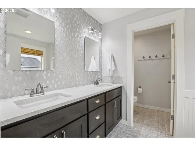 a bathroom with a double vanity sink and mirror