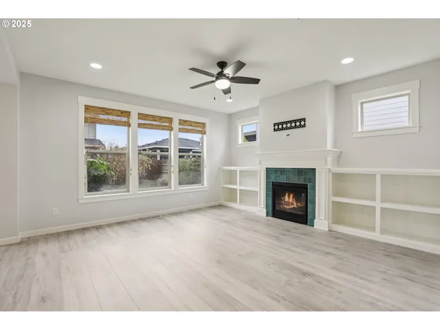 a view of an empty room with a window and fireplace