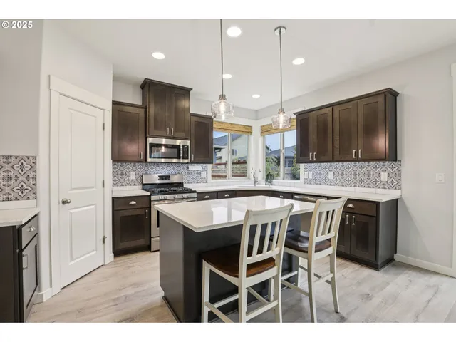 a kitchen with kitchen island granite countertop wooden cabinets and stainless steel appliances