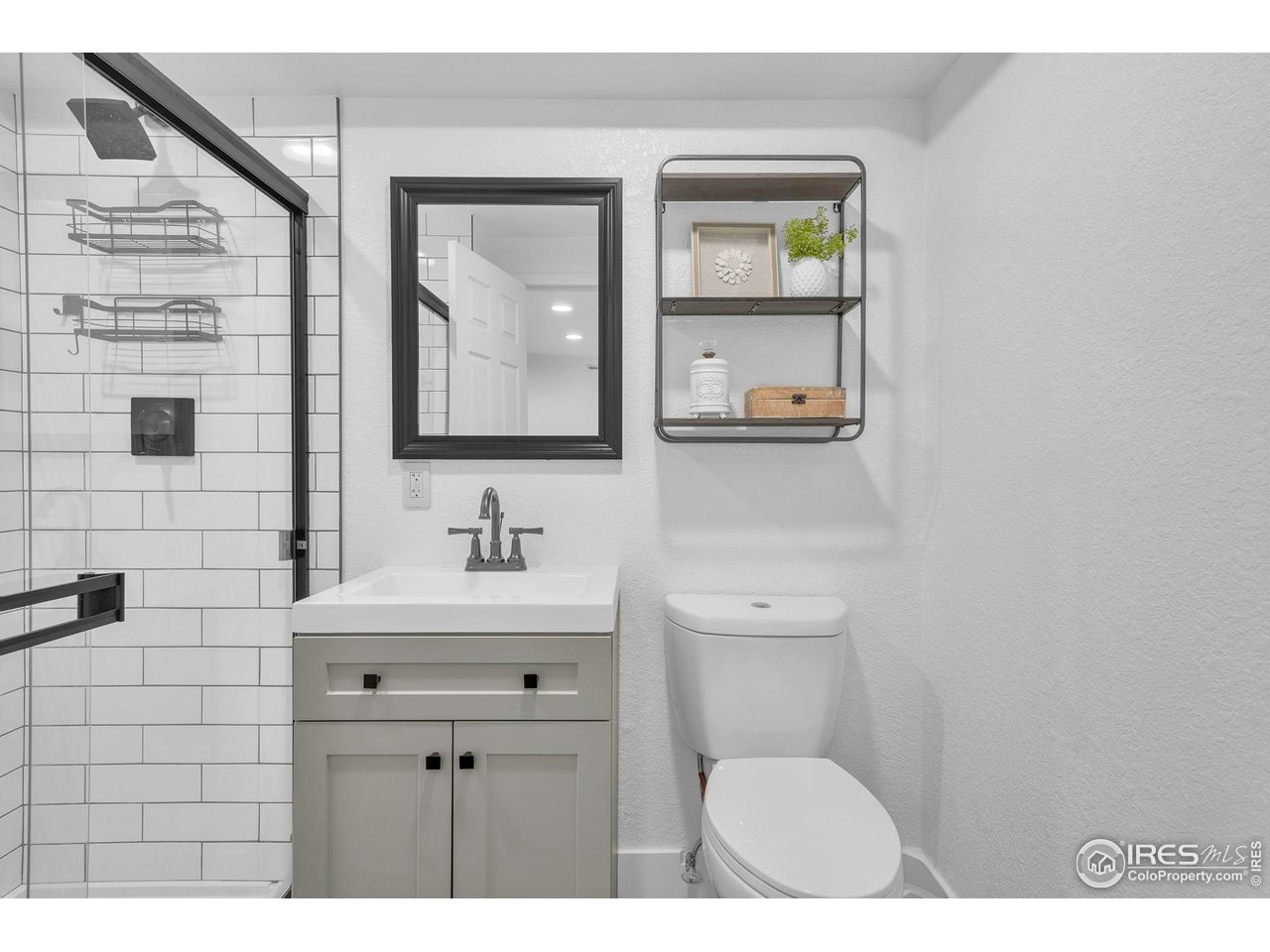 2808 Eaton Street Wheat Ridge, CO 80214 - Photo 14 of 35 a bathroom with a toilet a sink a mirror and a window