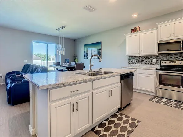 a kitchen with stainless steel appliances kitchen island granite countertop a sink stove and cabinets