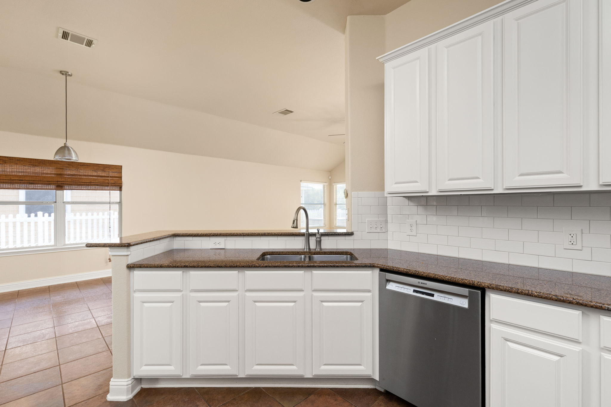 784 Sampson Kyle, TX 78640 - Photo 2 of 40 Granite counters and white cabinetry define this functional workspace opening to the living areas.