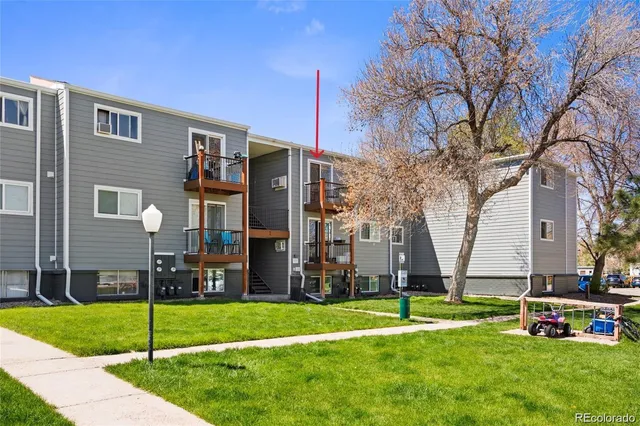 a view of a house with a yard and large tree
