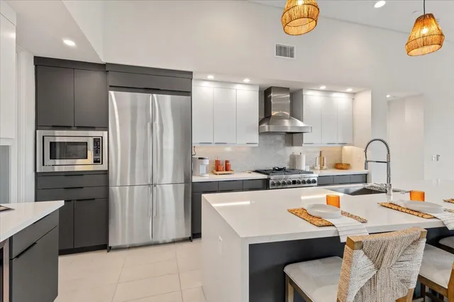 a kitchen with stainless steel appliances a stove refrigerator sink and microwave