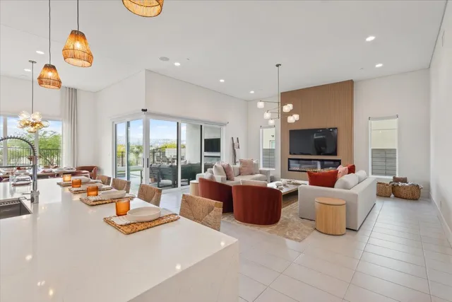 a living room with furniture kitchen view and a large window