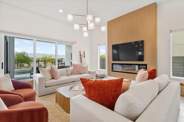 a living room with furniture a large window and a flat screen tv