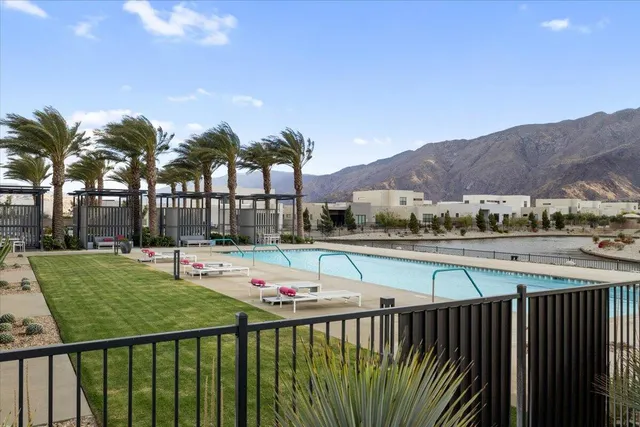 a view of a swimming pool with a patio and a yard