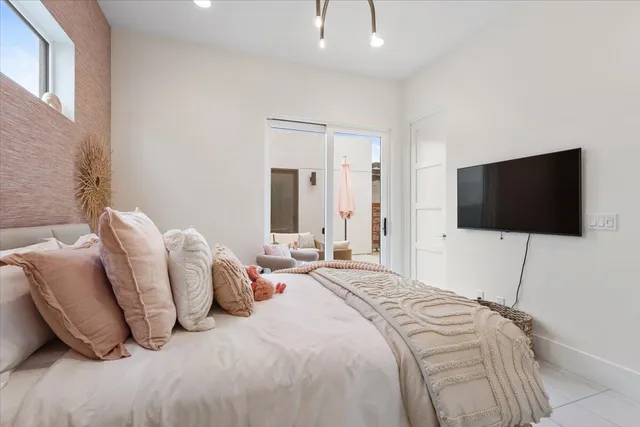 a bedroom with a bed and a flat screen tv