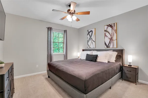 a bedroom with a large bed and a chandelier