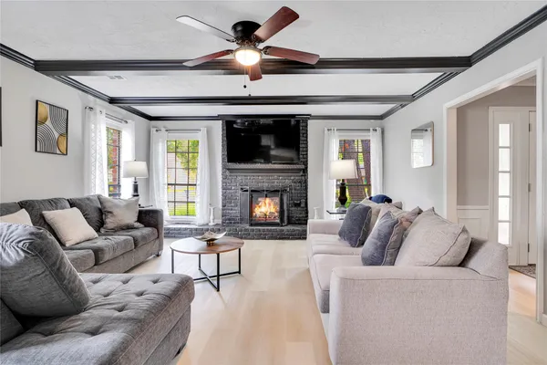 a living room with furniture a flat screen tv and a fireplace
